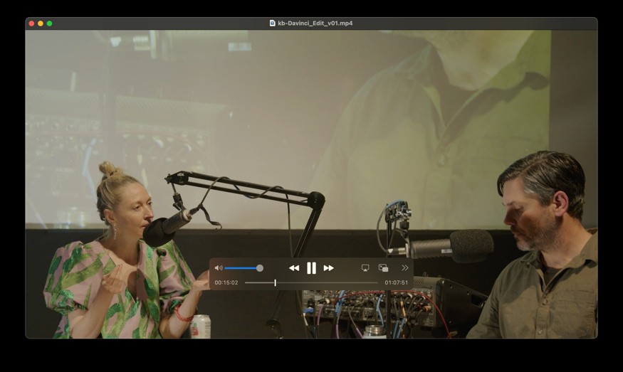 Ash Eliza Smith and Robert Twomey face each other across their microphones, with a live projection behind them.